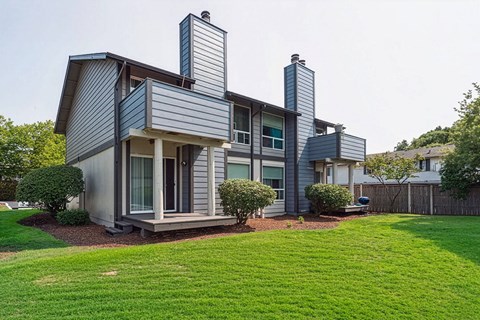 A modern house with a grey exterior and a well-maintained lawn.