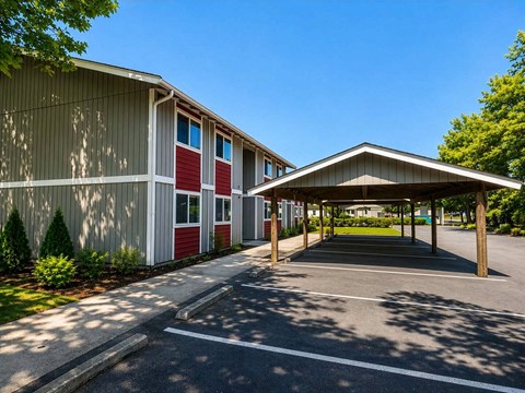 A parking lot with a building and a covered area.