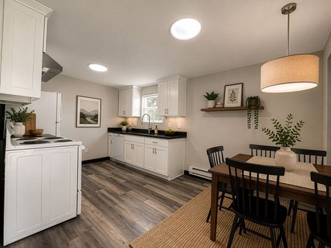 A kitchen with white cabinets and a wooden table.
