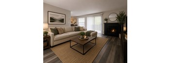 A living room with a white couch, a coffee table, and a fireplace.