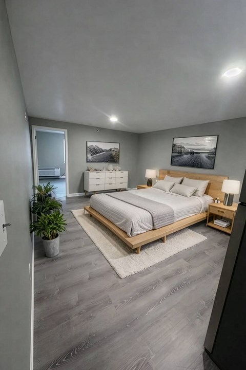 A modern bedroom with a large bed and a potted plant.