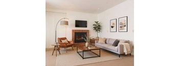 A living room with a fireplace, a couch, a chair, and a coffee table.