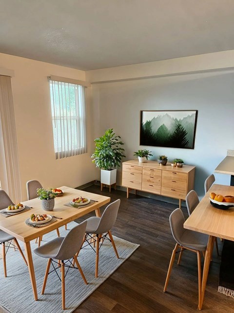 A dining room with a wooden table and chairs.