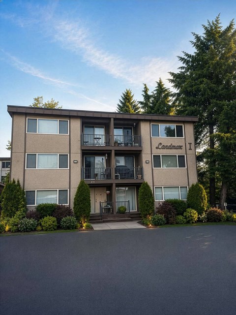 The image shows a multi-story apartment building named "Lorimer 1" with a parking lot in front and trees in the background.