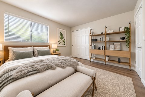 A bedroom with a large bed and a wooden shelf.