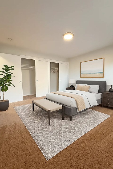 A bedroom with a large bed and a bench in front of it.