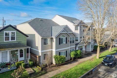 A row of houses with a car parked in front of the last one.
