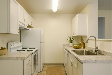 A kitchen with white appliances and cabinets.