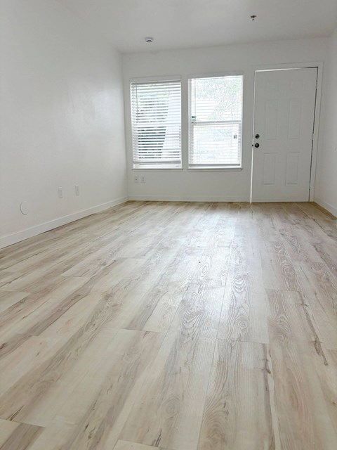 A room with a white door and a window with blinds.