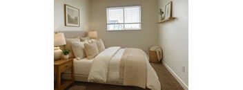 A bedroom with a large bed and a window.