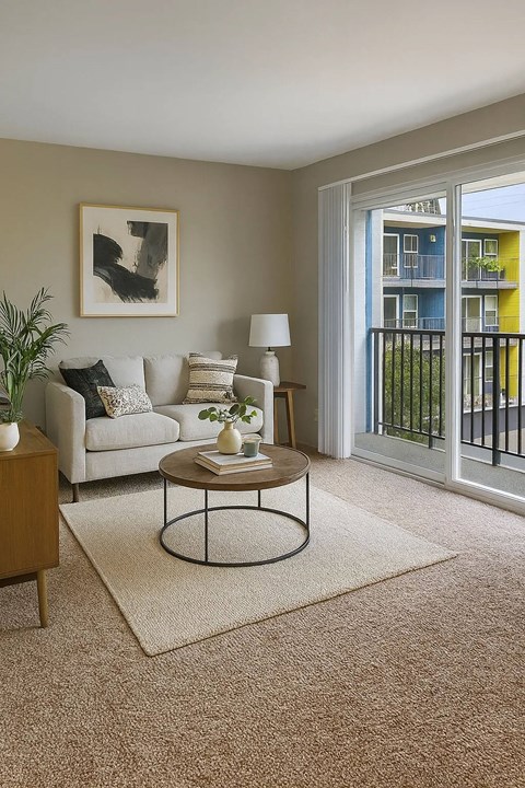 A living room with a white couch, a coffee table, and a painting on the wall.