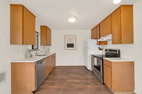 A kitchen with wooden cabinets and a white fridge.