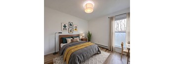 A bedroom with a bed, a chair, and a window.