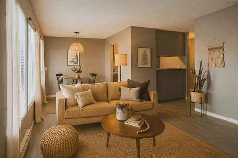 A living room with a beige couch, a coffee table, and a lamp.