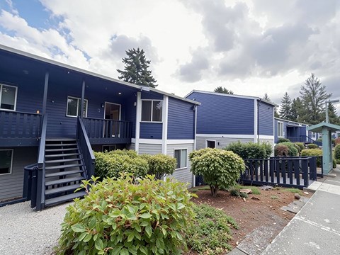 A blue building with a black railing and a green roof.