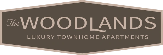 The image is a logo for "The Woodlands Luxury Townhome Apartments".