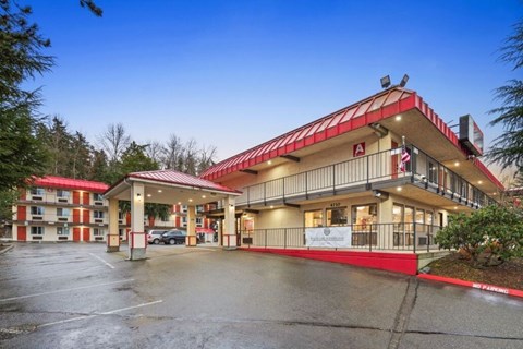 A red and white building with a parking lot in front.