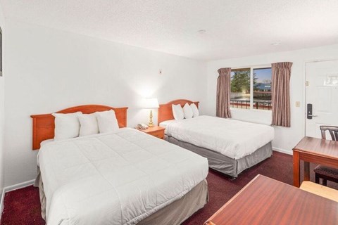 A bedroom with two beds and a table.