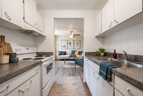 A kitchen with white cabinets and a rug on the floor.