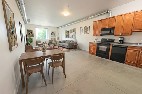 A kitchen with a dining table and chairs in the middle of the room.