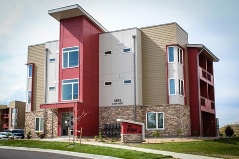 A multi-story building with a red and beige exterior and the Edge sign on the front.