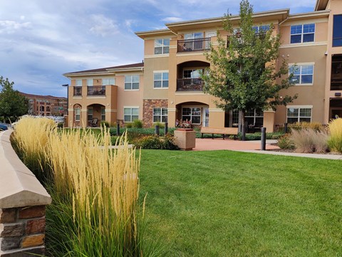 A large apartment complex with a grassy area in front.