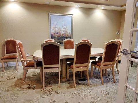 A conference room with a large table and chairs.
