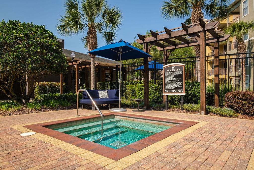a small pool in a courtyard with a sign and a chair