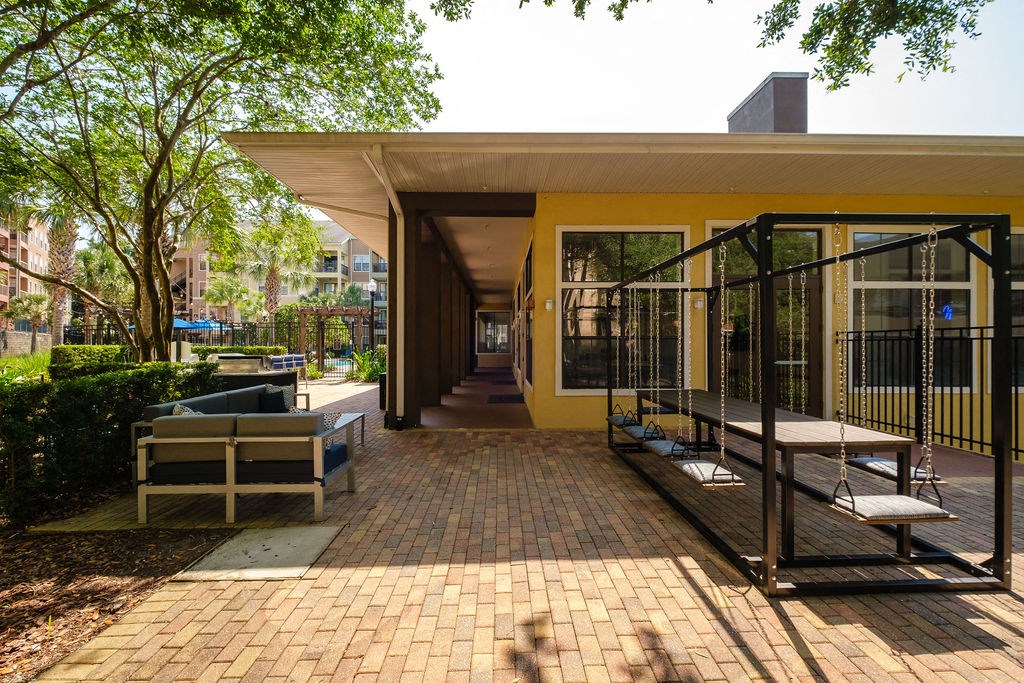 a patio with benches and a building in the background