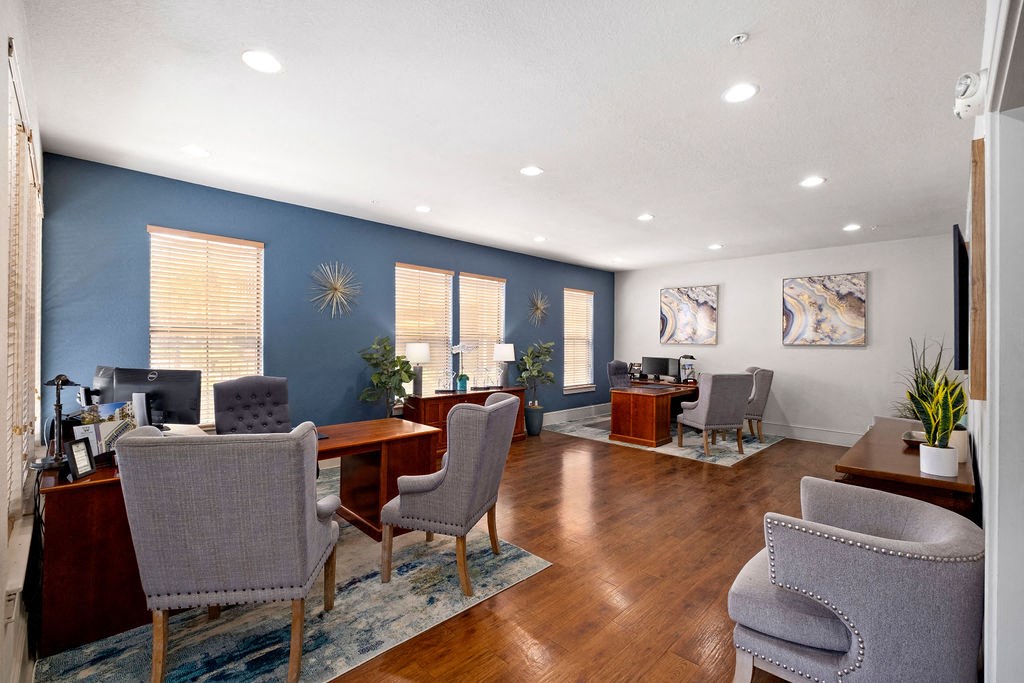 an office with blue walls and a wood floor and chairs