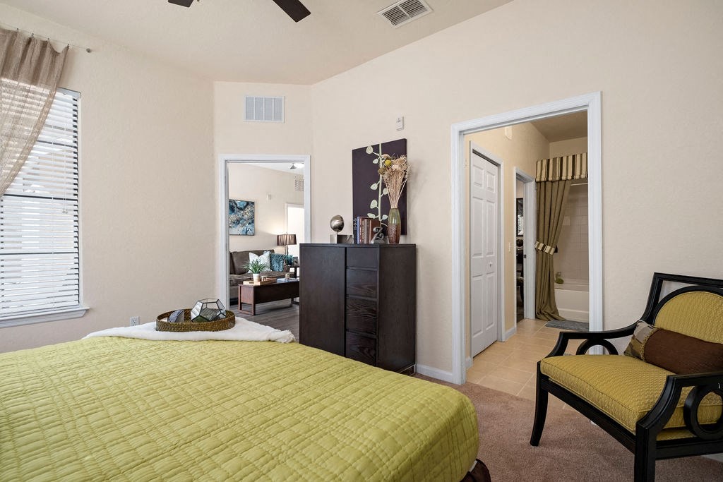 a bedroom with a bed and a door to a living room