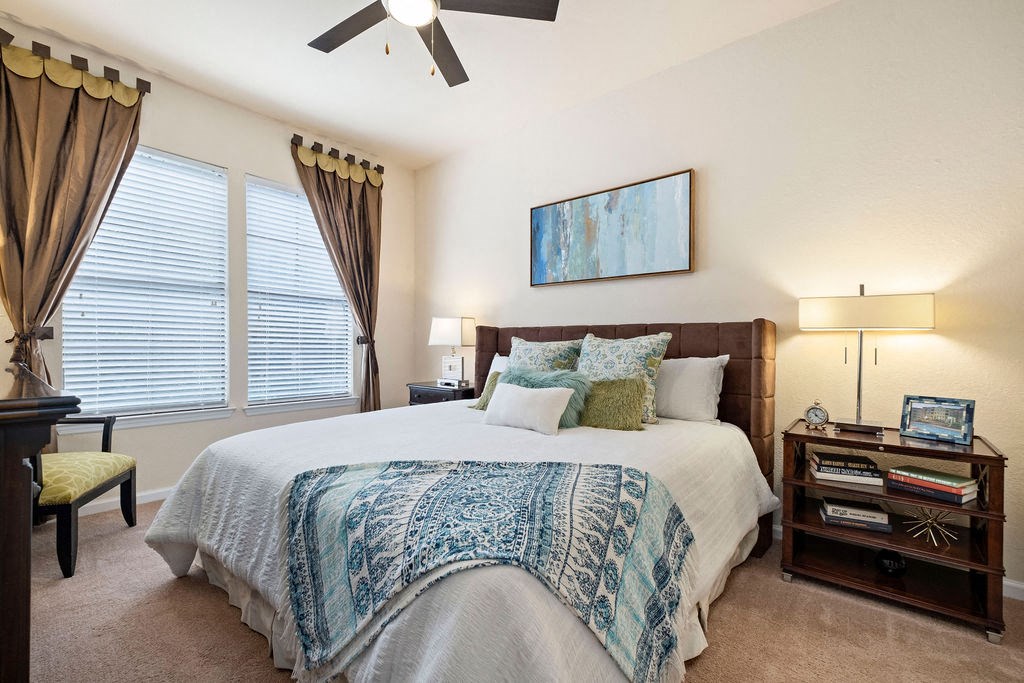 a bedroom with a bed and a ceiling fan