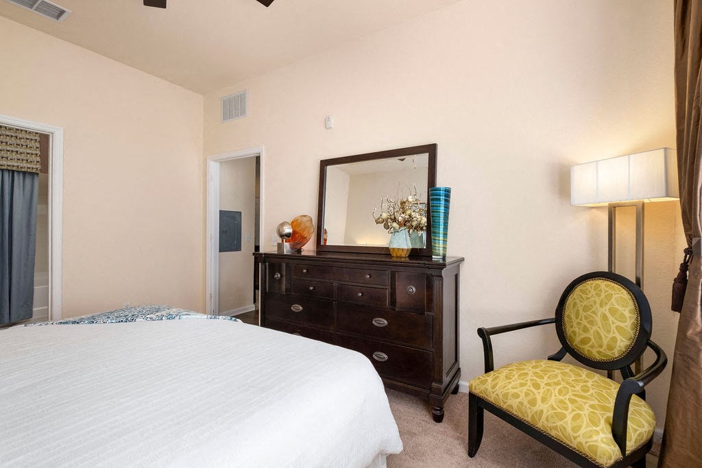 a bedroom with a bed and a dresser with a mirror