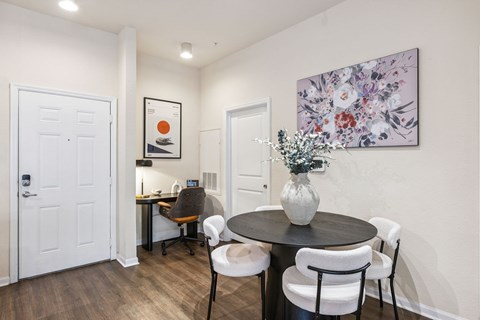A dining room with a table and chairs.