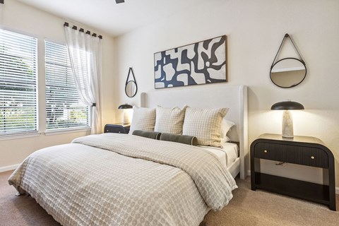 A bedroom with a large bed and a painting on the wall.