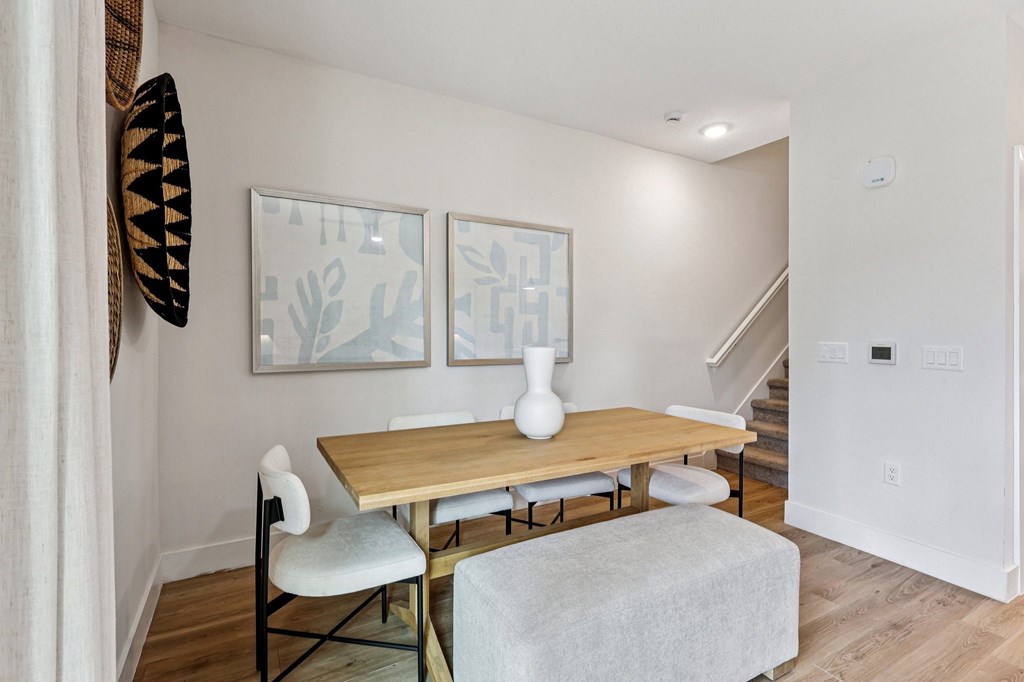 A dining room with a wooden table and chairs.