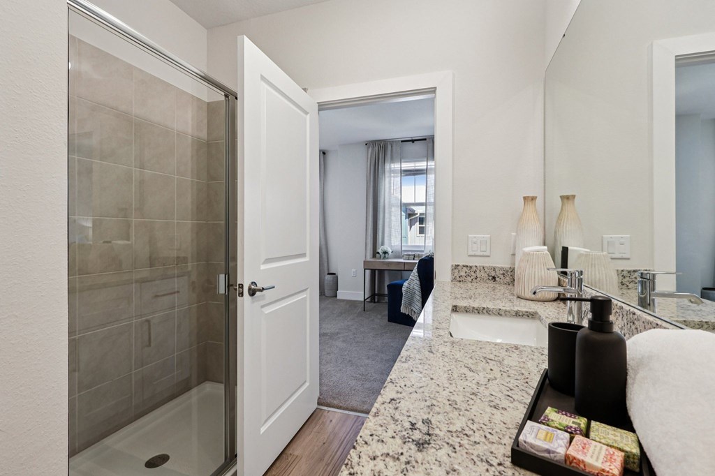 A bathroom with a glass shower door and a white sink.
