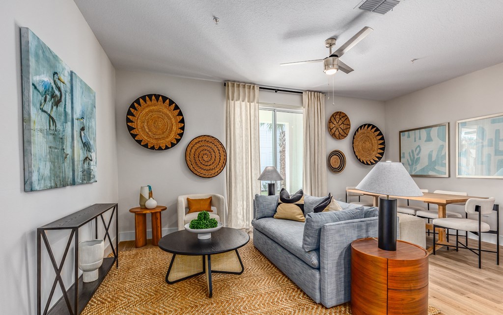 a living room with a couch and a table and a ceiling fan