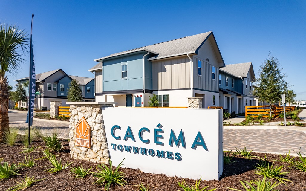the community sign for cascade townhomes with houses in the background