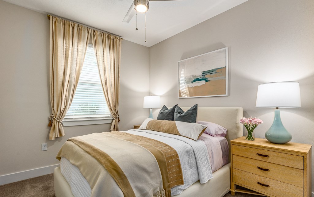 a bedroom with a bed and a dresser and a window