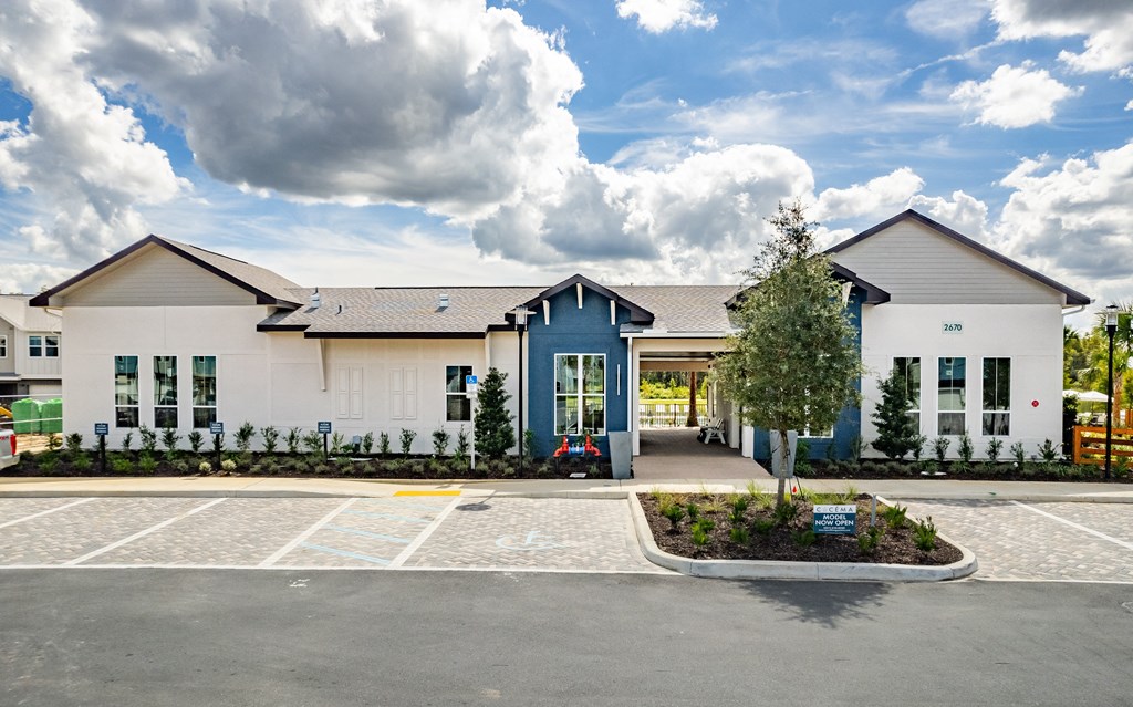 the exterior of a building with a parking lot and a blue and white facade