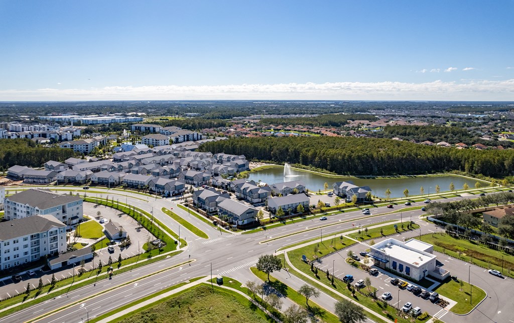an aerial view of a city with roads and buildings and a lake
