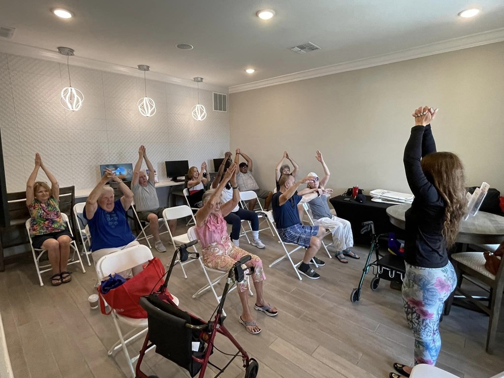 a group of people sitting in a room with their hands in the air