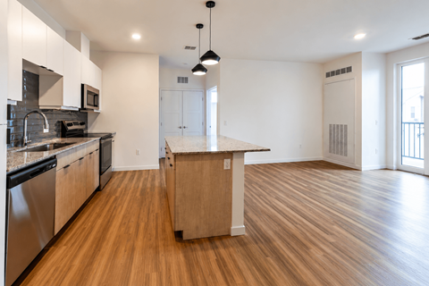 A kitchen with wooden floors and a central island.