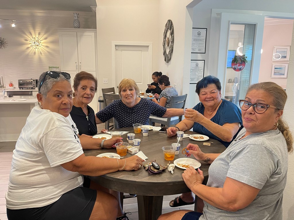 A group of people are sitting around a table eating food.