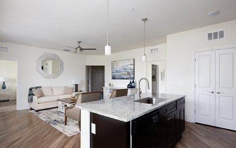 a view of a living room and a kitchen with a granite counter top