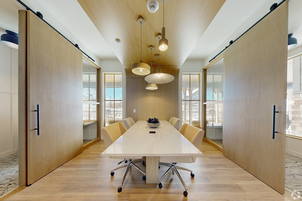 A conference room with a long table and chairs.