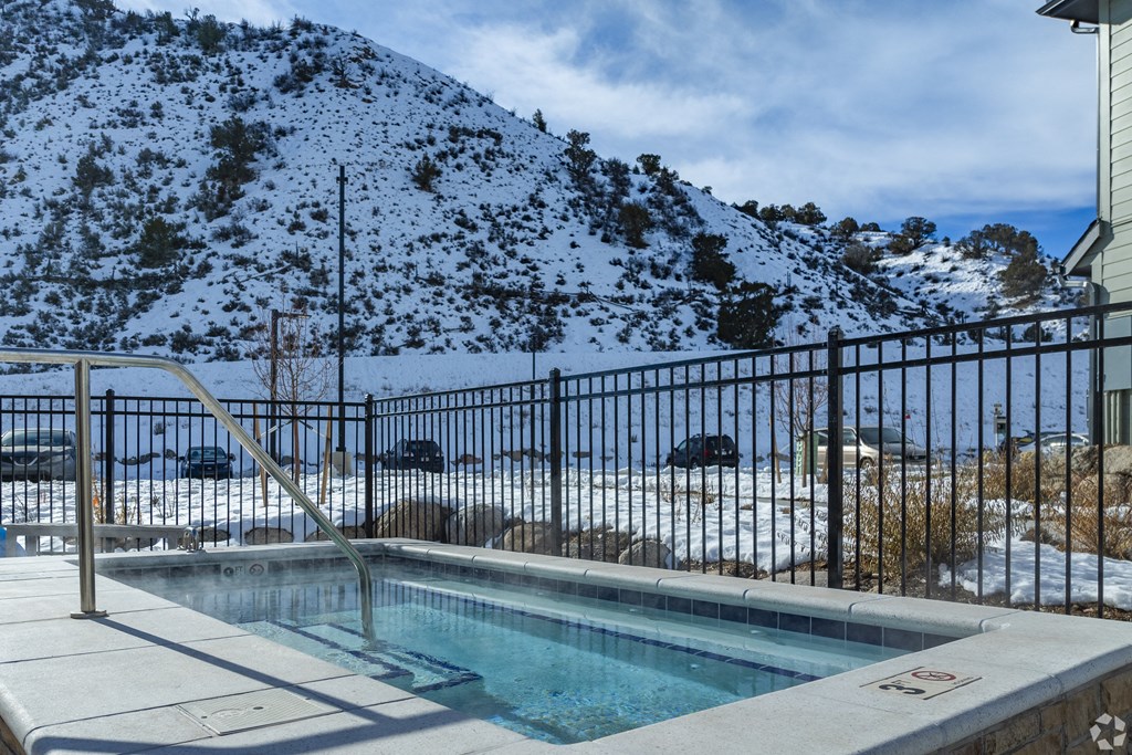 A pool surrounded by a fence with a mountain in the background.