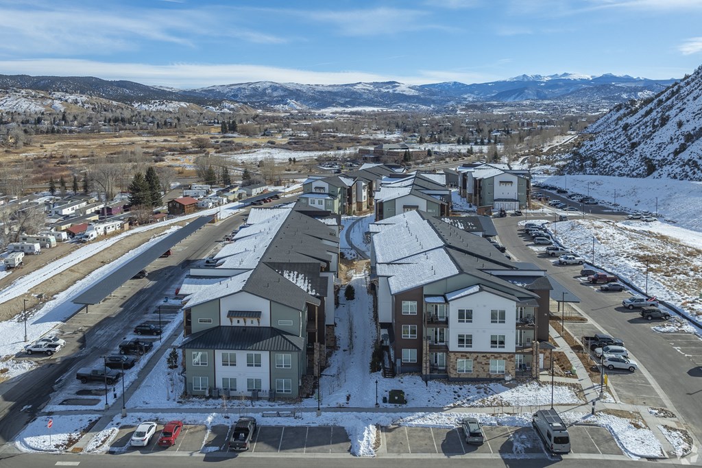 A large building complex with a parking lot in front of it.