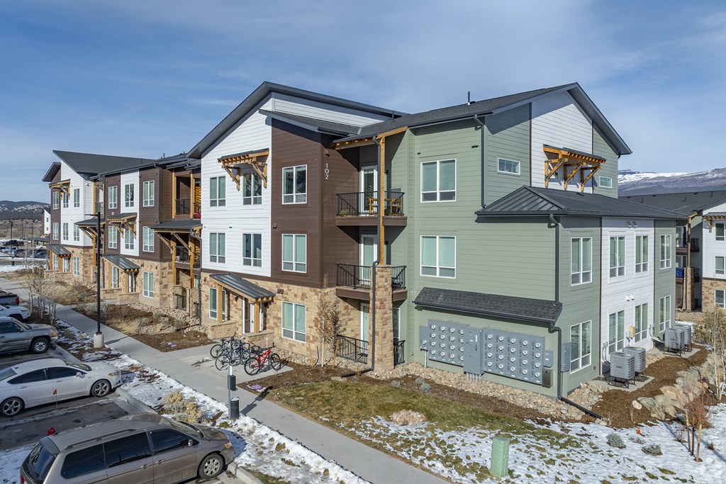 A row of modern houses with cars parked in front.